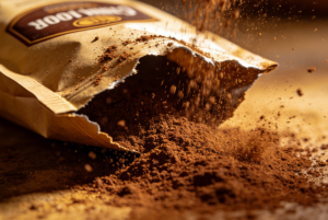 Messy static electricity coffee powder sticking to the sides of a flexible pouch during filling